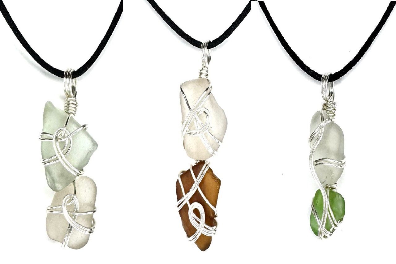 Beach glass pieces wrapped with wire and hung on black necklace cord