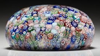 photo of glass paperweight with multicolored pieces of glass inside 