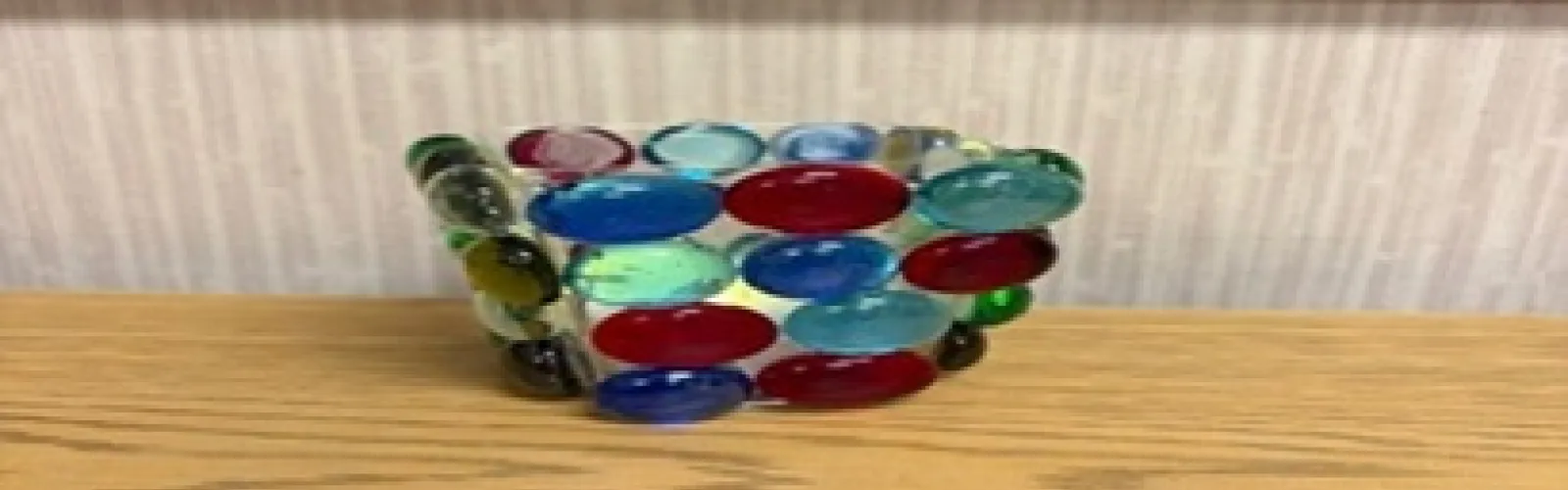 candle holder with colored glass beads glued to the outside with a battery operated votive candle inside